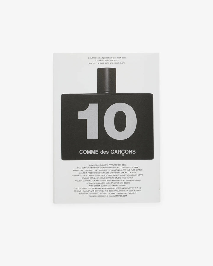 Cover of the Comme des Garçons Parfums 1994–2025 book by Dino Simonett, showing a close-up of an amber Eau de Parfum bottle on a pale grey background - view 2