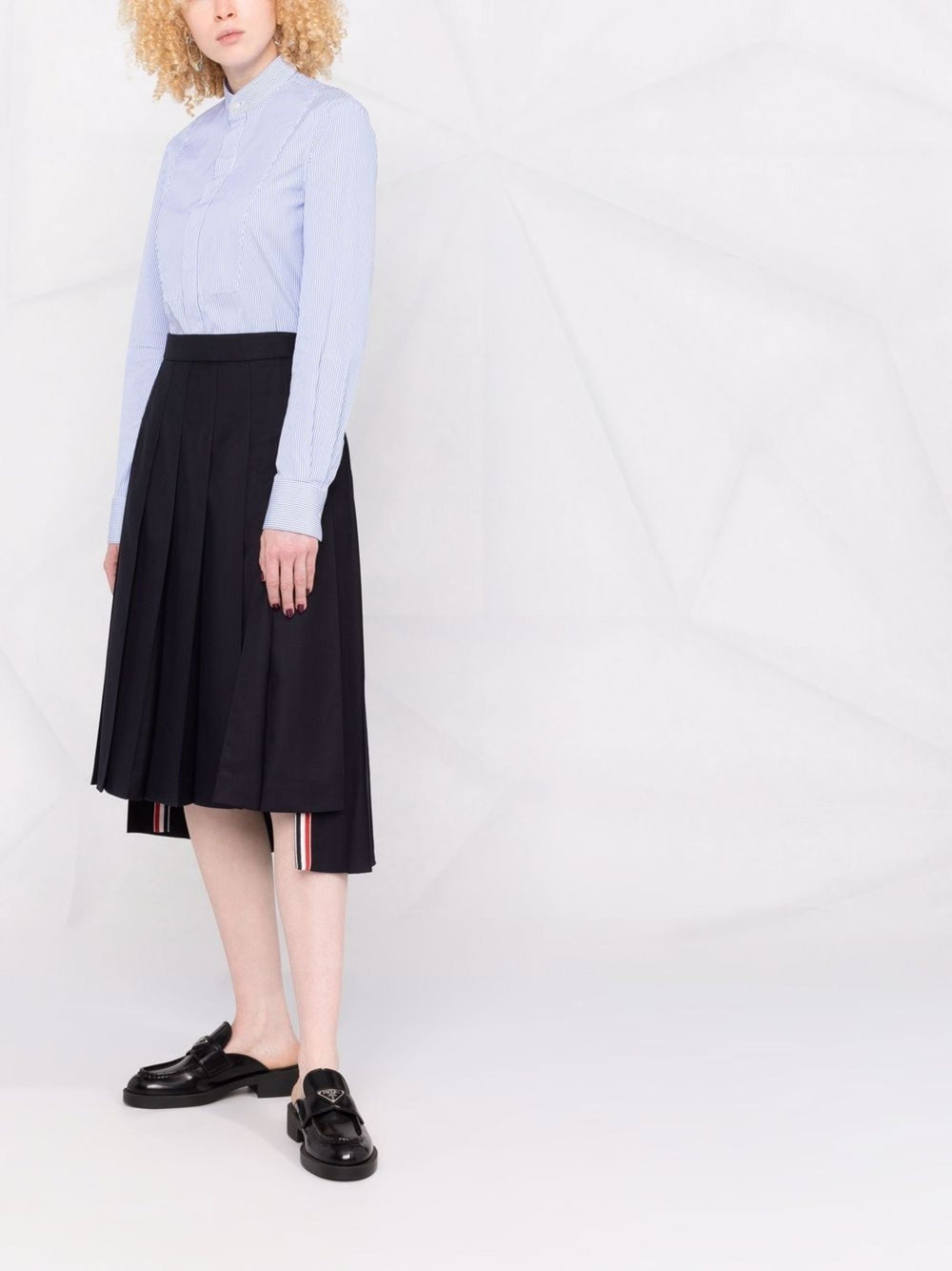 Thom Browne navy twill pleated midi skirt with tricolour grosgrain stripe hem trim, front view on white background