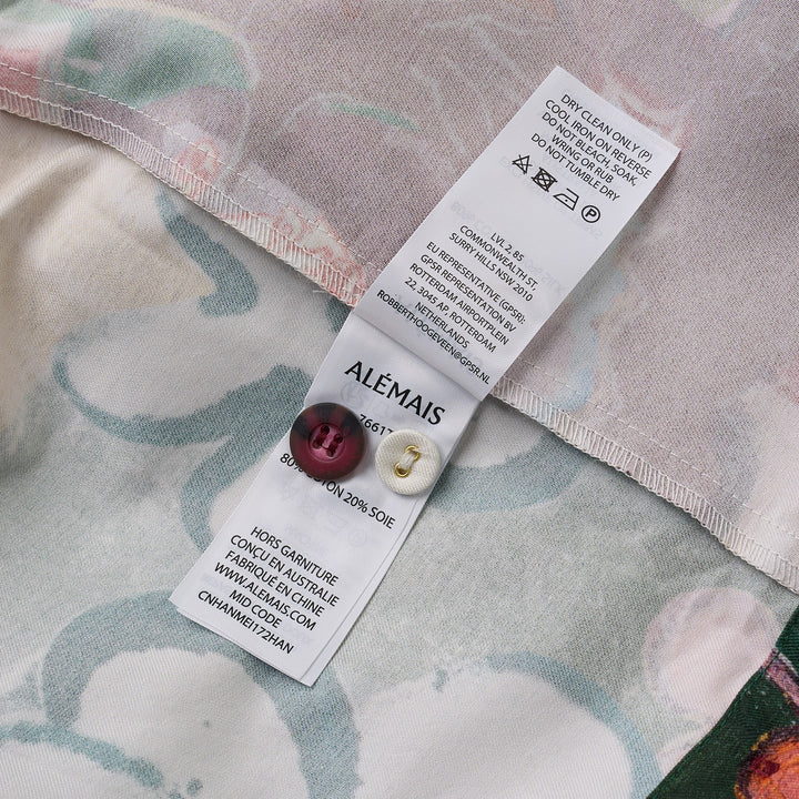 Alemais Tangible Love short-sleeve shirt with patchwork hand-painted panels featuring crocodile, floral, and abstract motifs, oversized hem pockets, and contrast stripe trim on a white background