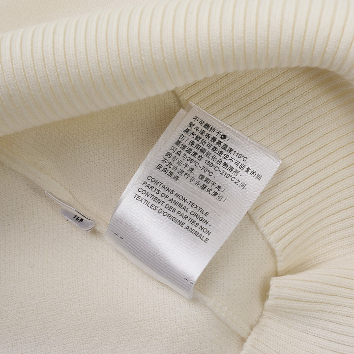 Thom Browne white short sleeve knit polo with red and white striped collar, signature red, white, and blue stripe on both sleeves, and four-button placket