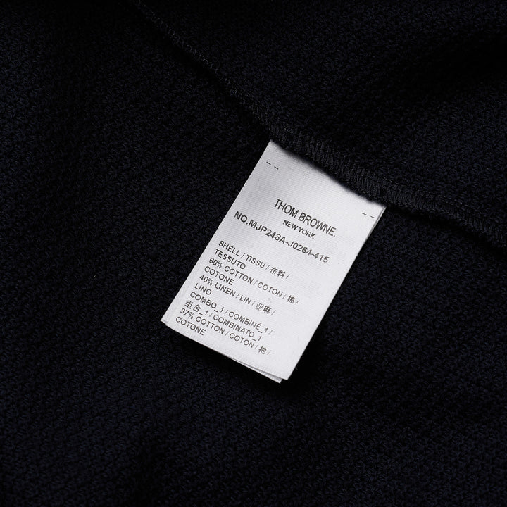 Thom Browne navy textured knit relaxed fit short sleeve polo with spread collar, five-button placket, chest pocket, and signature branding tab at the hem