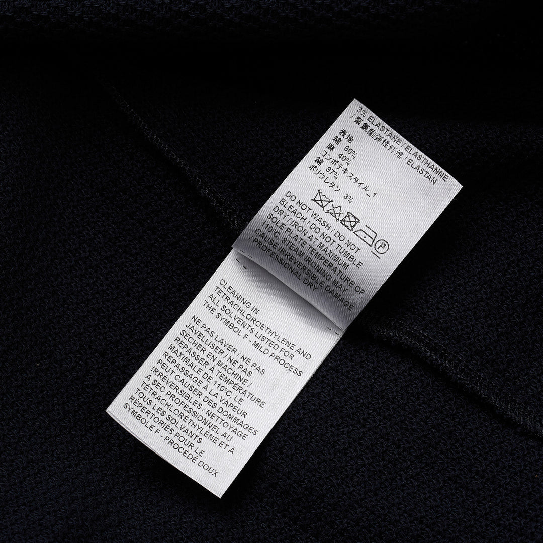 Thom Browne navy textured knit relaxed fit short sleeve polo with spread collar, five-button placket, chest pocket, and signature branding tab at the hem