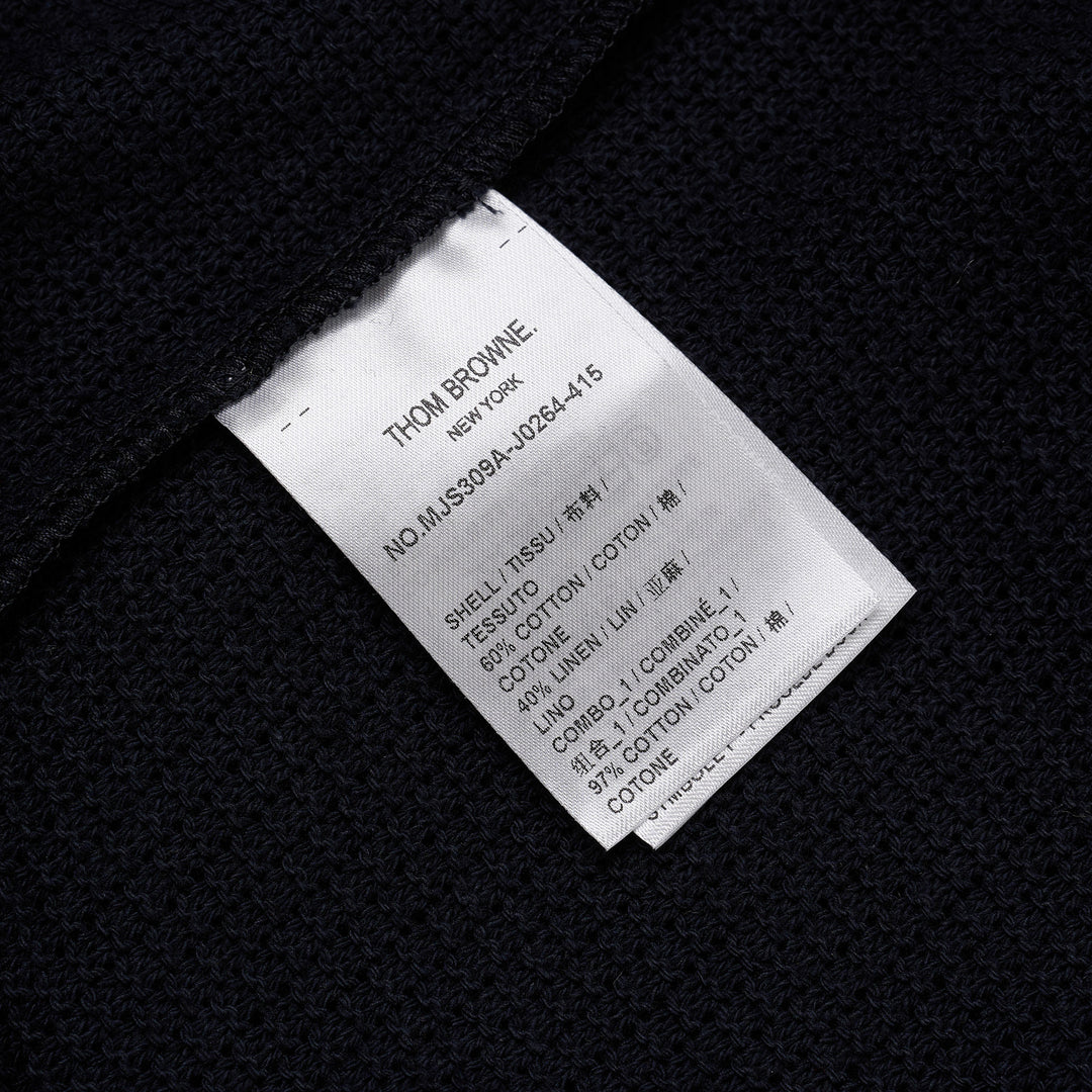 Thom Browne navy open-knit relaxed short sleeve tee with red, white, and blue striped ribbed crew neck collar and chest patch pocket
