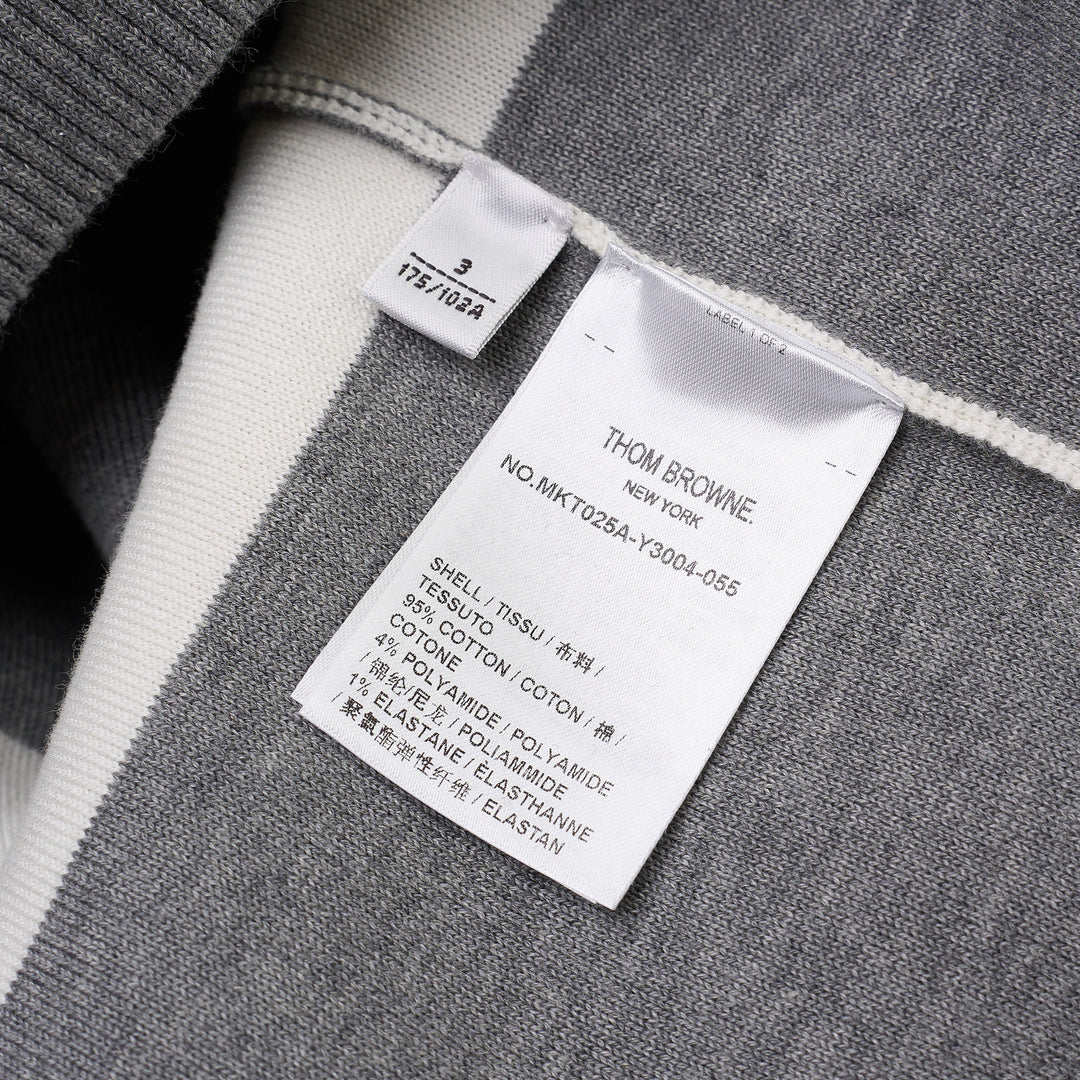Thom Browne rugby stripe zip-up hoodie in heathered grey and white with signature four-bar stripe on sleeve, full-length zip, drawstring hood, and ribbed hem