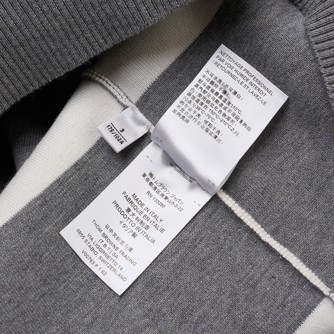 Thom Browne rugby stripe zip-up hoodie in heathered grey and white with signature four-bar stripe on sleeve, full-length zip, drawstring hood, and ribbed hem
