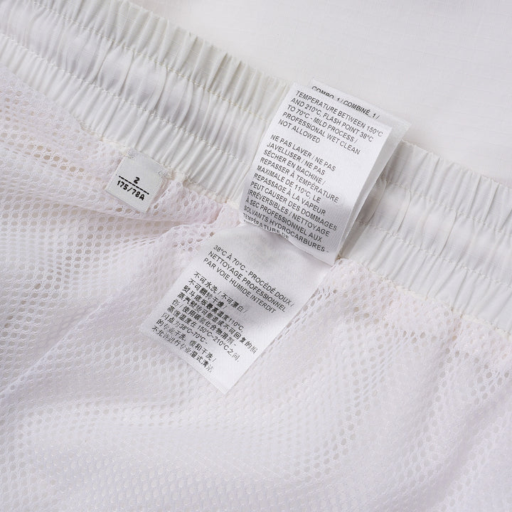 Thom Browne white drawcord waist track shorts with signature 4-bar navy stripe across the hem and elasticated waistband