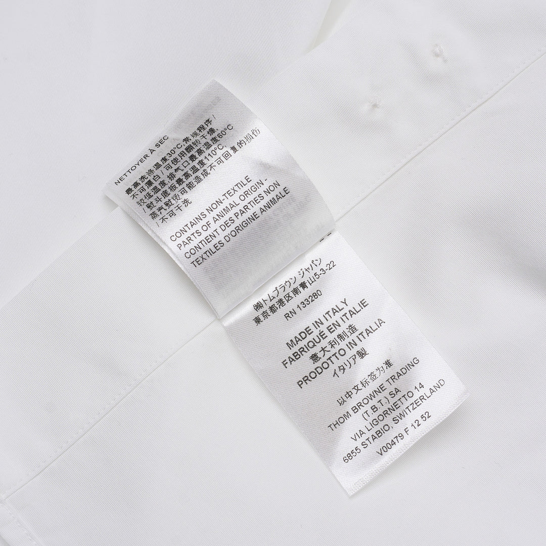 Thom Browne white long sleeve point collar shirt with signature red, white, and blue four-bar stripe on the sleeve, button-front placket, and chest pocket