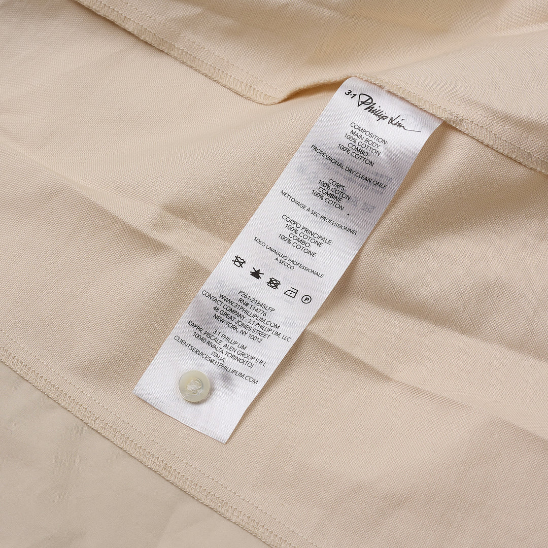 3.1 Phillip Lim Tonal Poplin Flutter Sleeve Blouse in ivory, featuring an asymmetric diagonal strap with button detail and dual hip patch pockets