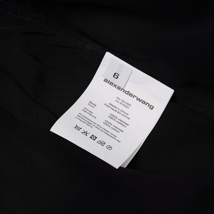 Alexander Wang mid-rise shorts with acid-wash denim waistband and pleated black fabric body, featuring silver snap button and contrast orange topstitching