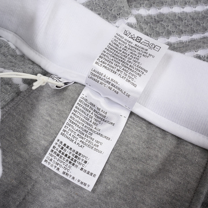 Thom Browne grey and white striped honeycomb-textured knit shorts with white ribbed waistband, drawstring tie with stripe detail, and woven brand label at hem - view 4