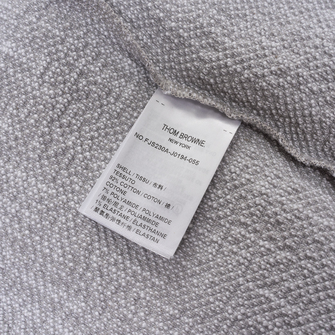 Thom Browne heather grey textural knit short sleeve tee with red, white, and blue striped tipping on sleeve cuffs and hem, white ribbed crew neck and hem band, and woven brand label on chest - view 3