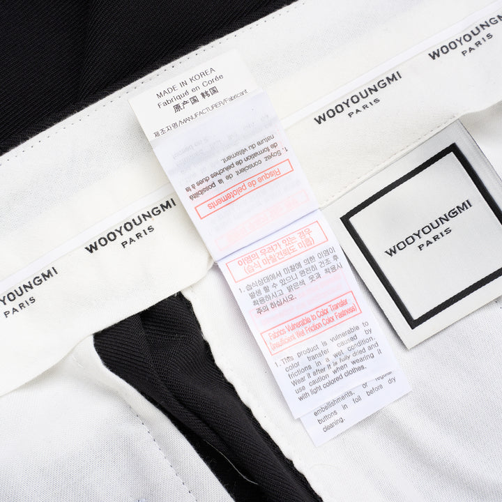 Wooyoungmi black pleated high-rise trousers with double front pleats and side metal buckle adjuster, displayed flat on white background - view 6