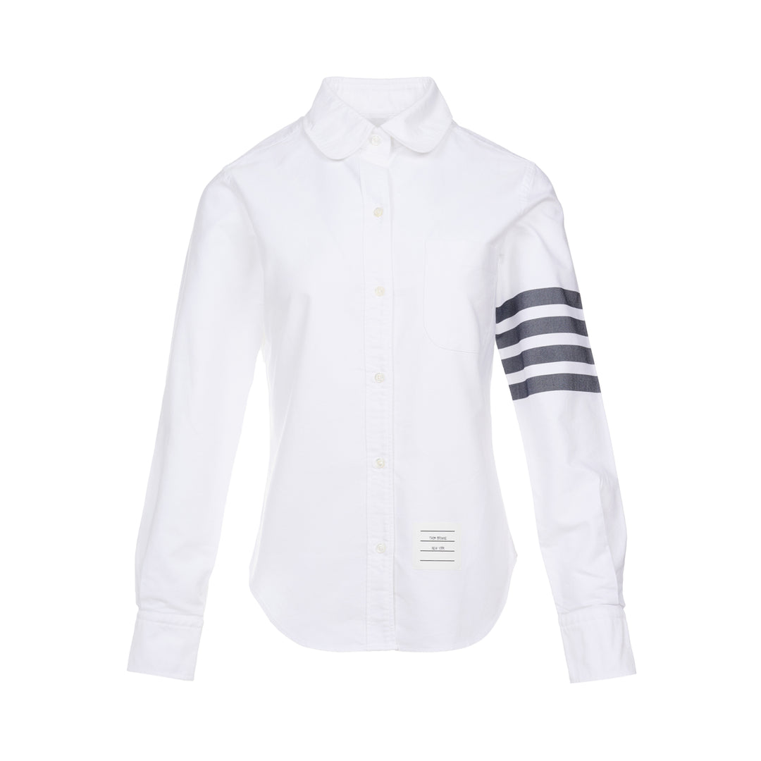 Thom Browne white oxford long sleeve shirt with rounded collar, button-front placket, single chest pocket, and signature four-bar grey stripe across one sleeve