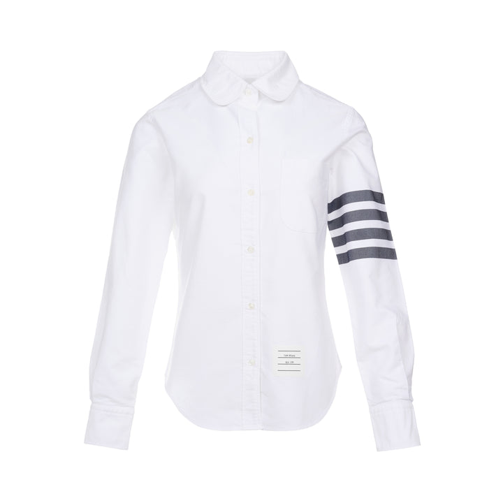 Thom Browne white oxford long sleeve shirt with rounded collar, button-front placket, single chest pocket, and signature four-bar grey stripe across one sleeve