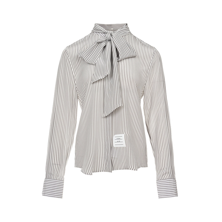 Thom Browne grey and white vertical stripe long sleeve blouse with detachable pussy-bow collar, contrast horizontal-stripe cuffs, and signature woven label patch at the hip