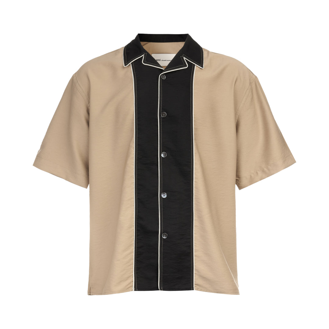 AMI Alexandre Mattiussi Shark Collar Boxy Short Sleeve Shirt in tan and black with contrast cream piping and button-through front, flat lay on white background