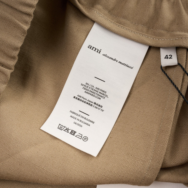 AMI Elasticated Large Bermuda Shorts in khaki tan, featuring a wide-leg silhouette, elasticated paper-bag waistband with drawstring, and hem side slits, displayed flat on a white background - view 3