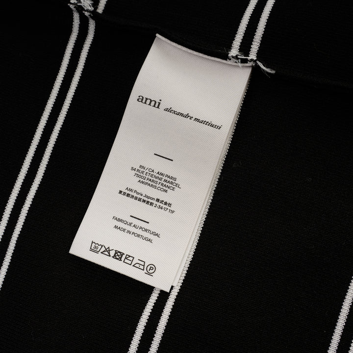 AMI Alexandre Mattiussi Long Sleeve Striped Polo in black with white horizontal stripes, featuring a spread collar, half-zip placket with heart logo pull, and ribbed cuffs - view 3