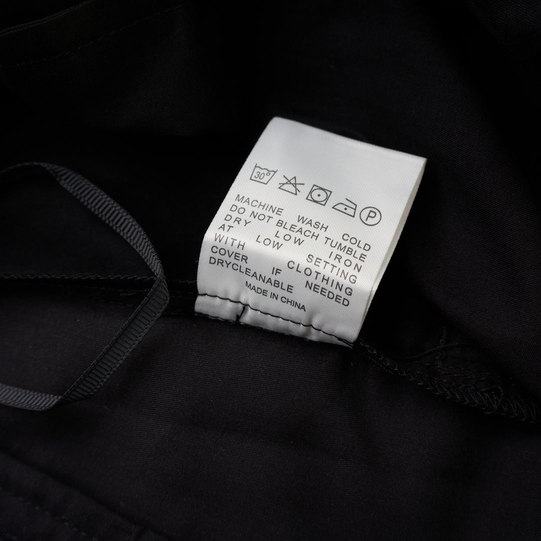 Black longline tailored shorts with a front box pleat, belt loops and concealed fly closure, shown from the front - view 4