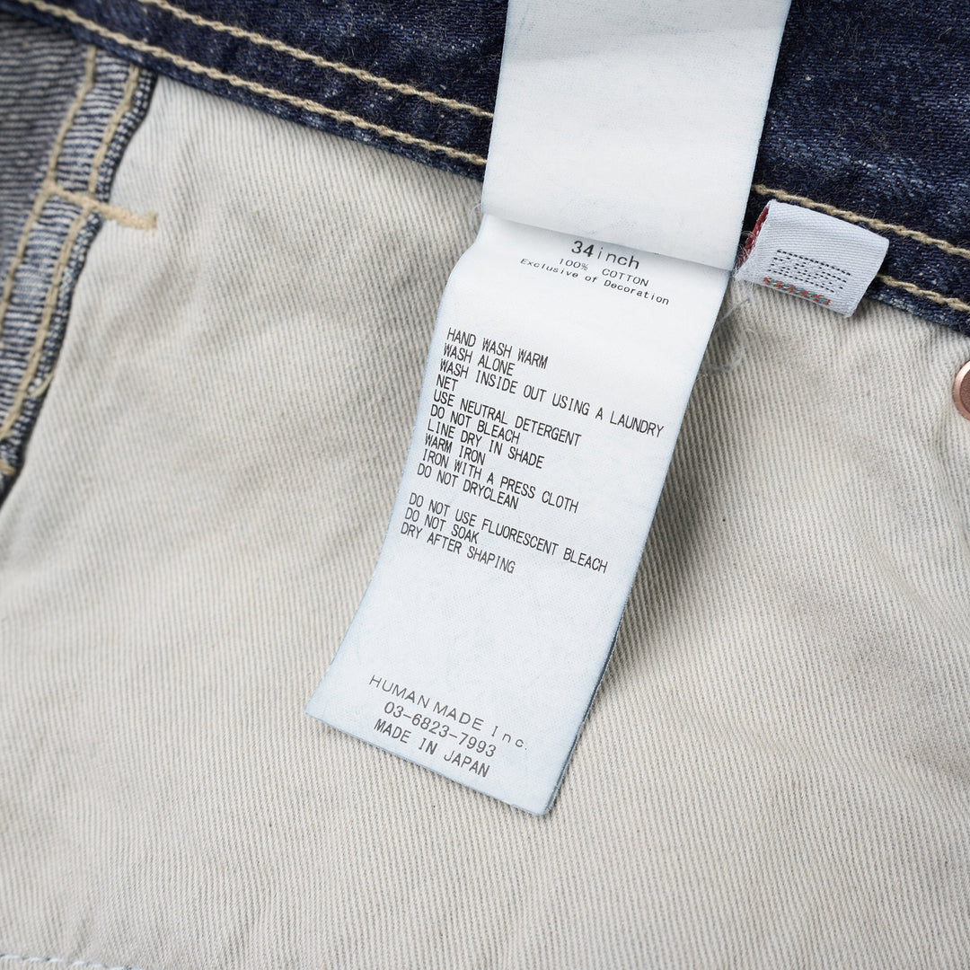 Human Made slim denim pants in a washed mid-indigo finish, shown front-facing with button fly and contrast topstitching - view 4