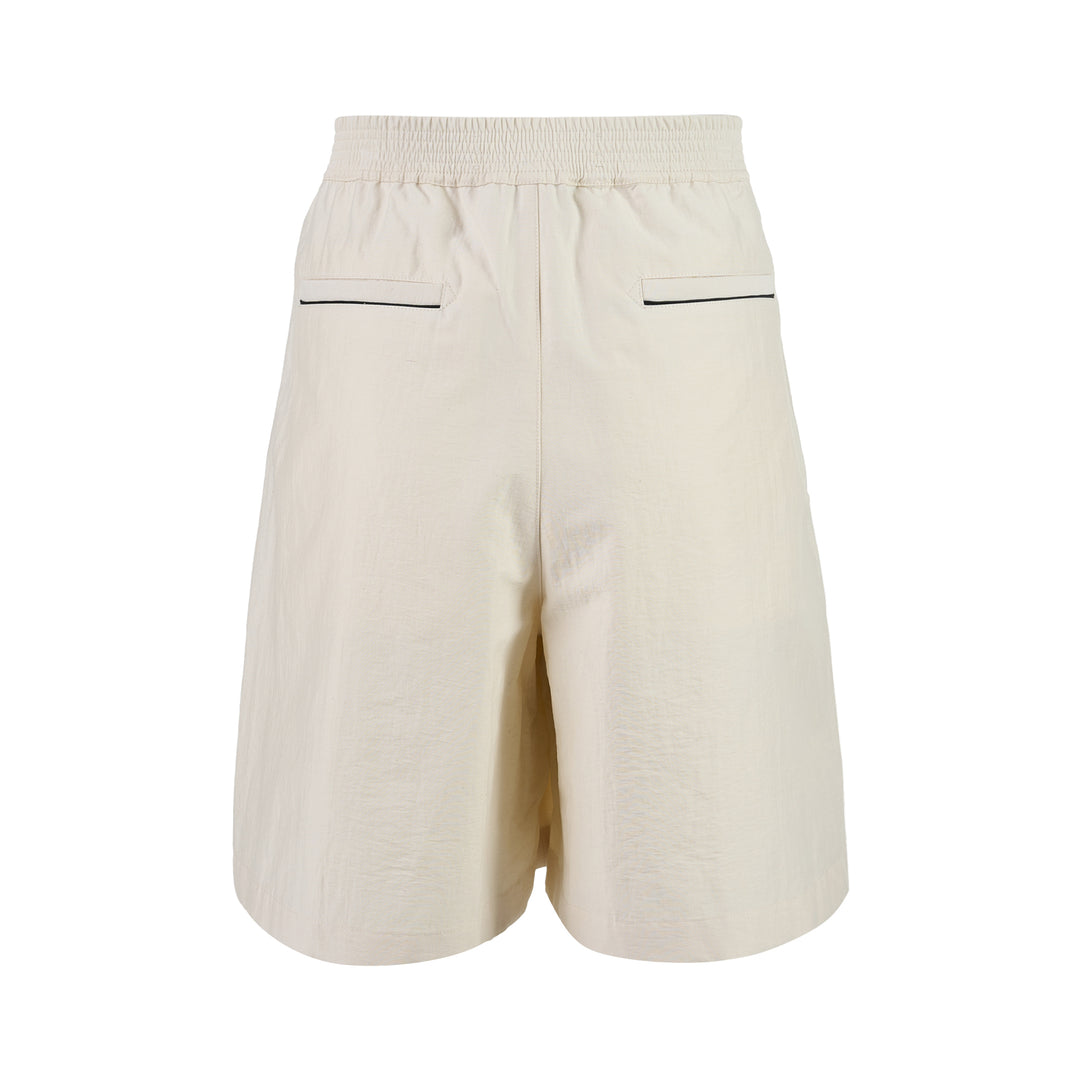 Jacquemus Le Short Pyjama cream pleated shorts with elasticated waistband, button closure and side piping, shown from the front - view 2