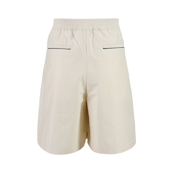 Jacquemus Le Short Pyjama cream pleated shorts with elasticated waistband, button closure and side piping, shown from the front - view 2
