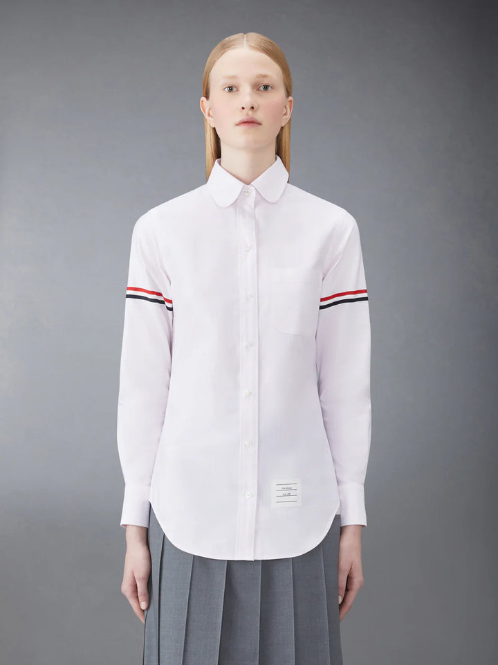 Thom Browne classic long sleeve light blue pinstripe shirt with tricolor grosgrain ribbon armbands, front view on white background