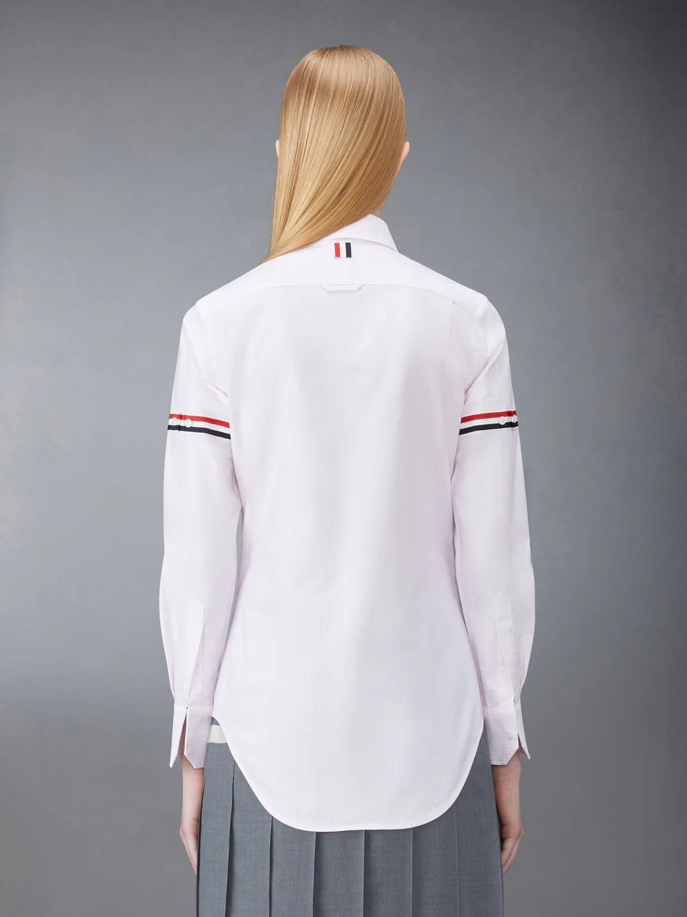 Thom Browne classic long sleeve light blue pinstripe shirt with tricolor grosgrain ribbon armbands, front view on white background