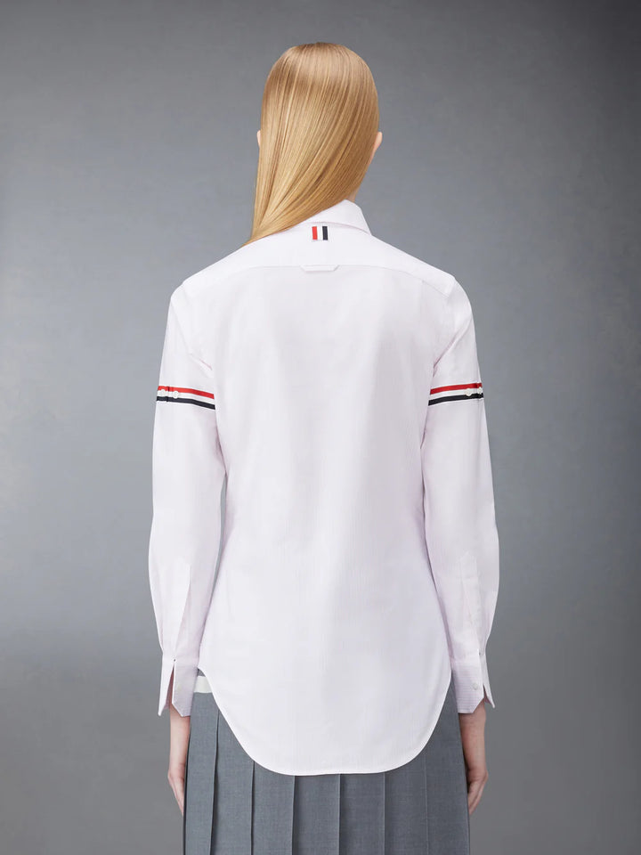 Thom Browne classic long sleeve light blue pinstripe shirt with tricolor grosgrain ribbon armbands, front view on white background