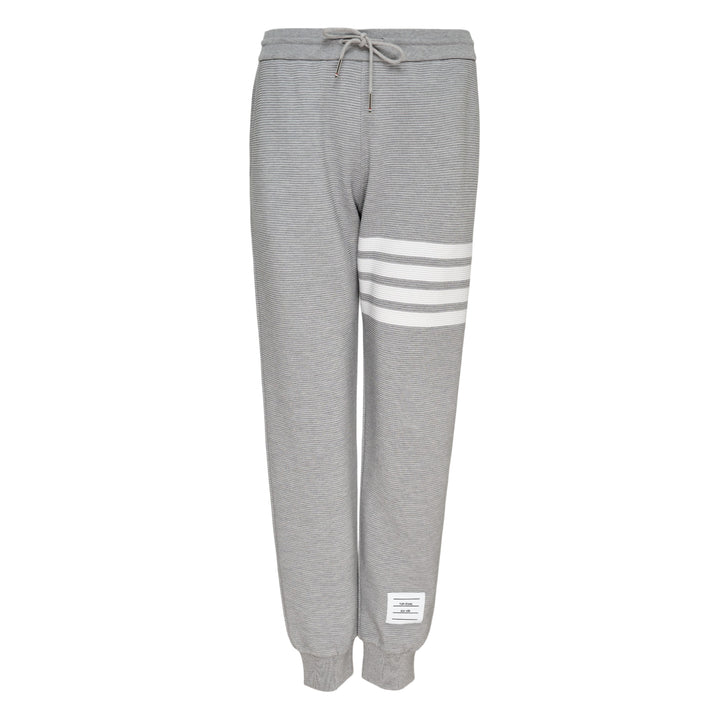 Thom Browne 4 Bar Cotton Sweatpants in heather grey with white four-bar stripe detailing on the thigh, drawstring waist and ribbed ankle cuffs