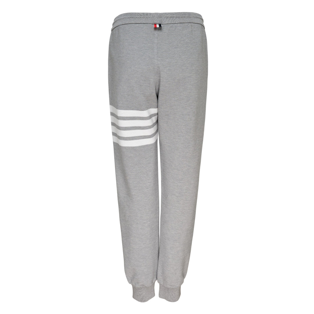 Thom Browne 4 Bar Cotton Sweatpants in heather grey with white four-bar stripe detailing on the thigh, drawstring waist and ribbed ankle cuffs