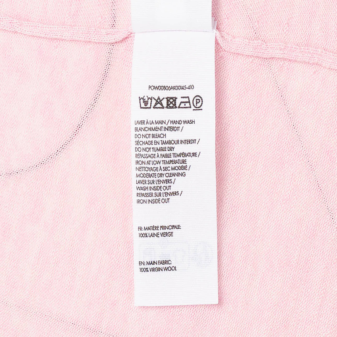 Jacquemus Le Polo Merino long-sleeve knit polo in blush pink with dark snap-button placket, ruched sleeves, and snap-button cuffs, displayed on a flat lay against a white background - view 3