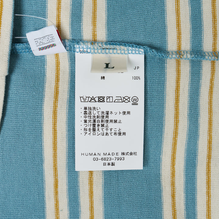 Human Made Striped Short Sleeve Tee in sky blue with horizontal multicolour stripes in cream, yellow, and blush, featuring an embroidered yellow heart logo patch at the chest