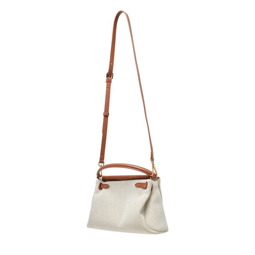 JW PEI Carmen Top Handle Bag in natural canvas with cognac leather frame, gold turnlock closure, and adjustable crossbody strap, shown on white background