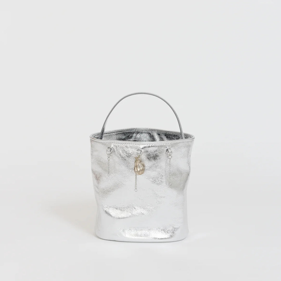 Marge Sherwood Wired Bucket Bag in crinkled metallic silver leather with a slim top handle and gold-tone charm on chain