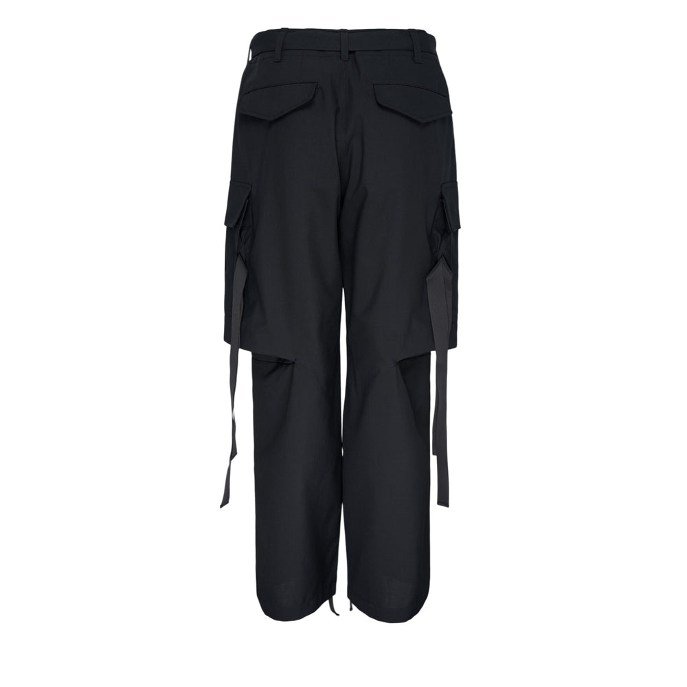sacai black suiting cargo pants with wide-leg silhouette, oversized flap pockets, belted waist, strap hardware, and drawstring hem