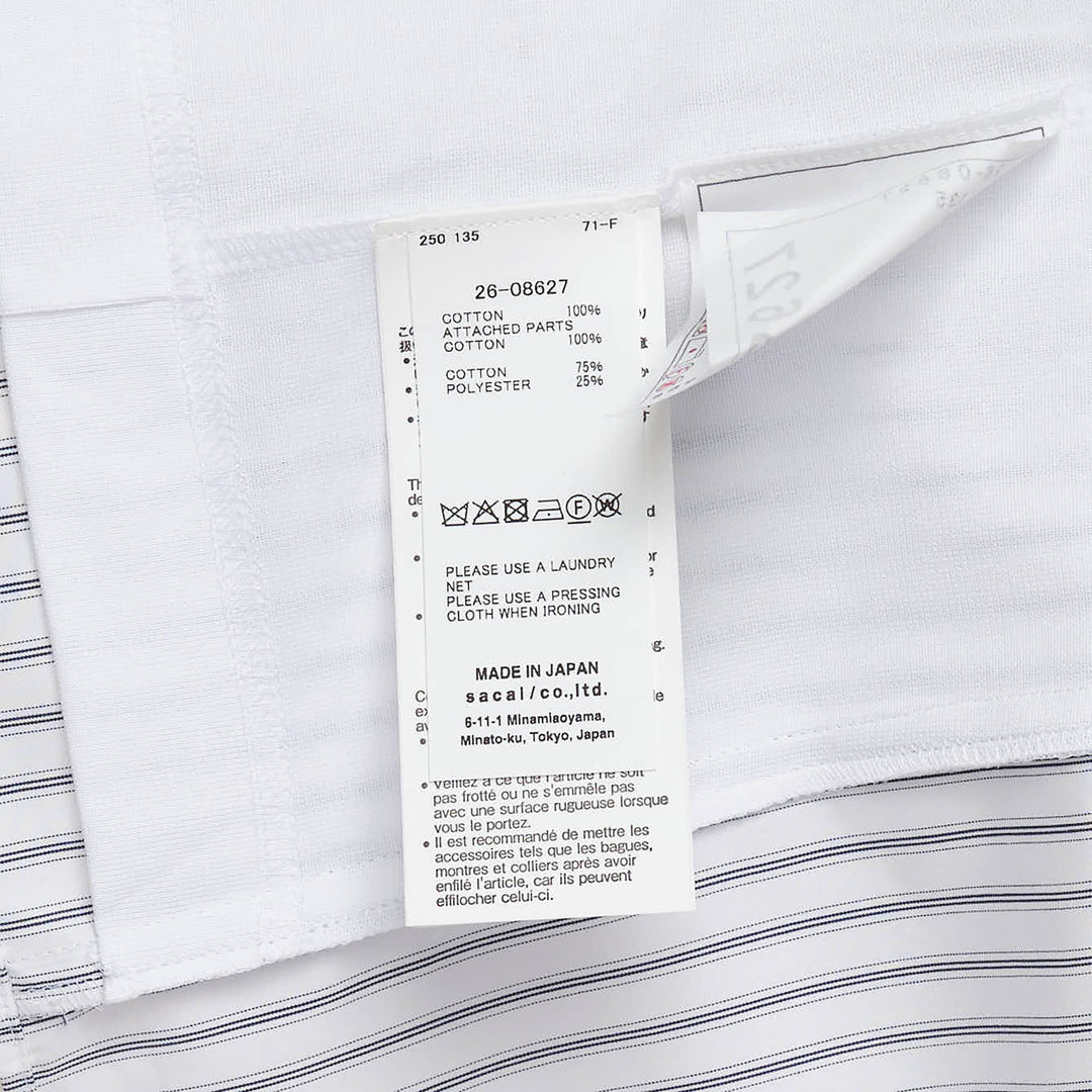 sacai Poplin x Cotton Jersey T-Shirt featuring a dark navy knit upper and a light blue vertical-striped poplin lower panel with a button placket, displayed flat on a white background