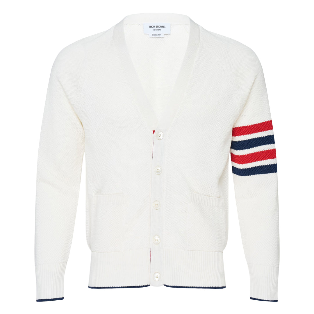 Thom Browne white tuck stitch relaxed cardigan with signature red, white, and blue 4-bar stripe on the sleeve, V-neckline, button-front fastening, and hip patch pockets