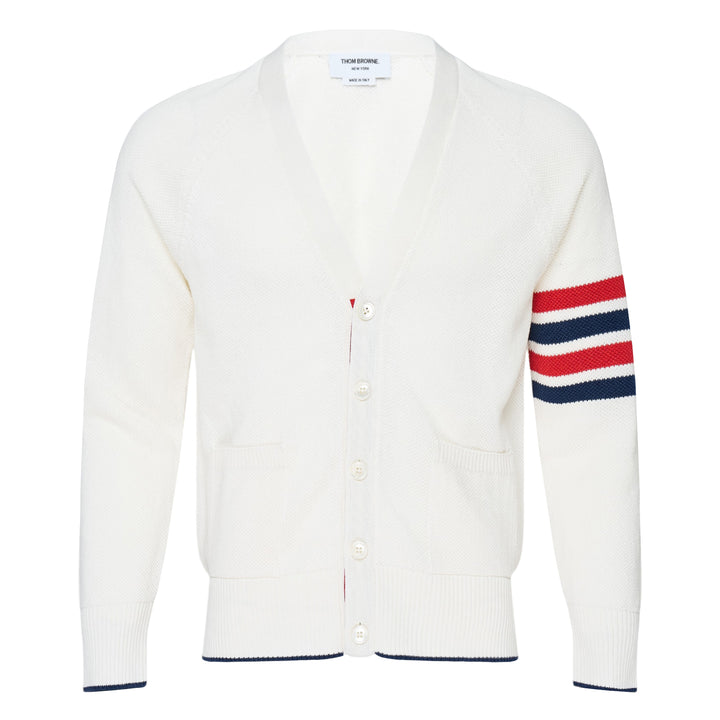 Thom Browne white tuck stitch relaxed cardigan with signature red, white, and blue 4-bar stripe on the sleeve, V-neckline, button-front fastening, and hip patch pockets