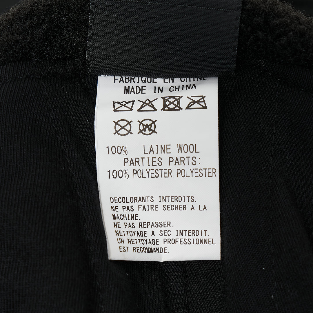 Y's all-black wool trapper hat with sherpa fleece lining, fold-down ear flaps with chin strap, and tonal embroidered Y's logo on the front panel, photographed from the front on a white background. - view 4