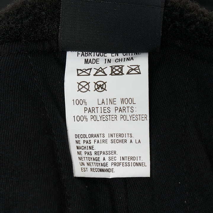 Y's all-black wool trapper hat with sherpa fleece lining, fold-down ear flaps with chin strap, and tonal embroidered Y's logo on the front panel, photographed from the front on a white background. - view 4