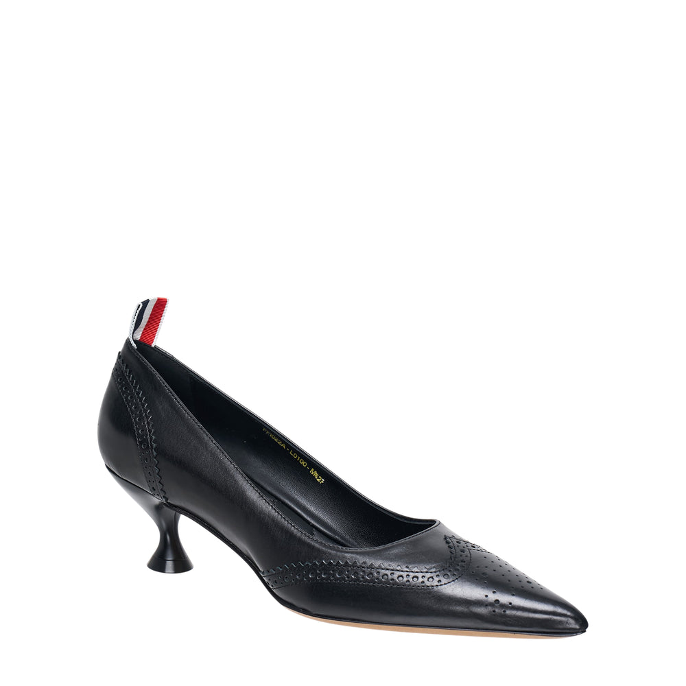 Thom Browne black leather wingtip brogue pump with sculptural 50mm round kitten heel, pointed toe, perforated detailing, and signature red, white, and blue heel tab
