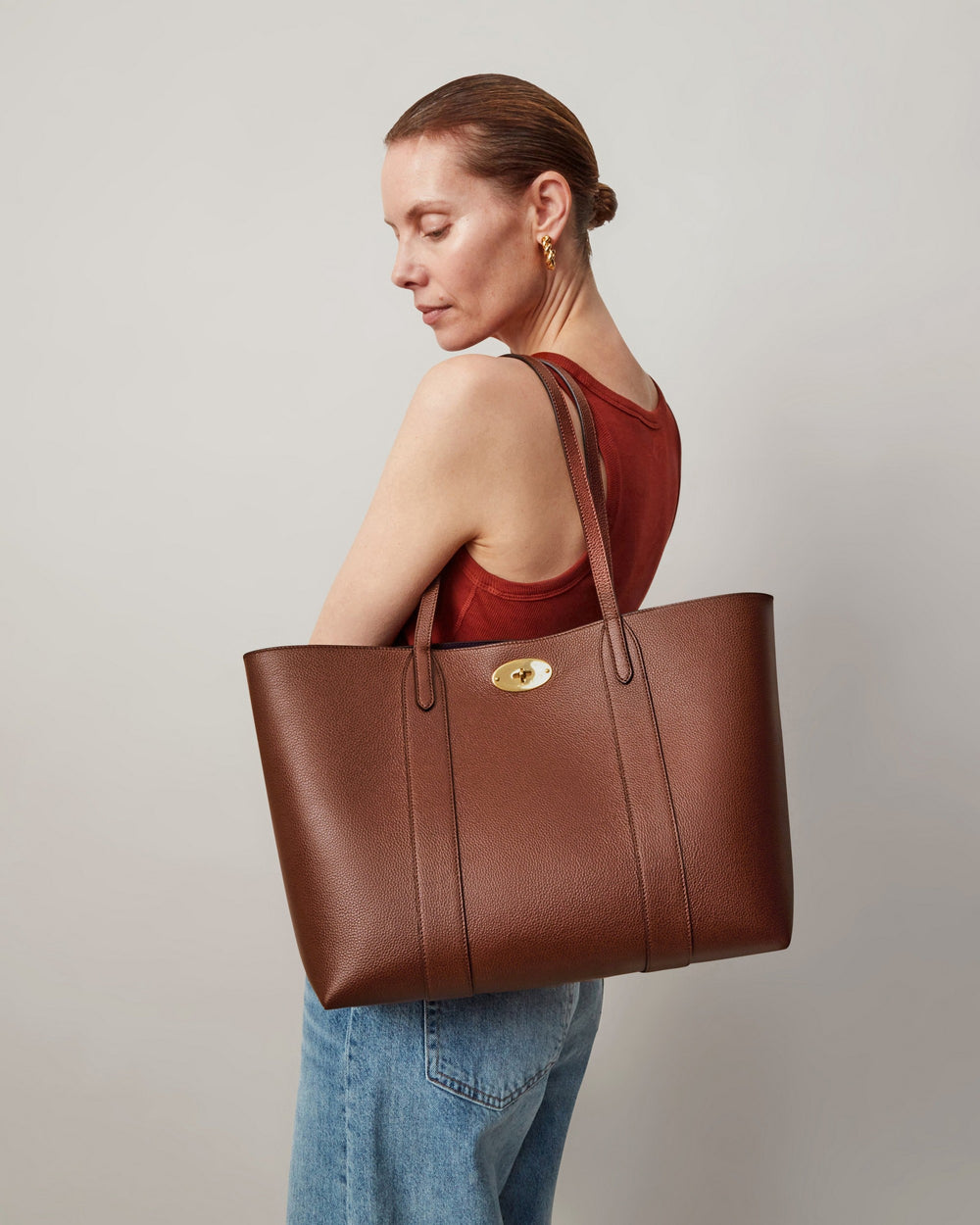 Mulberry Bayswater Two Tone Tote in tan pebbled leather with gold postman's lock closure and navy interior lining, shot against a neutral background