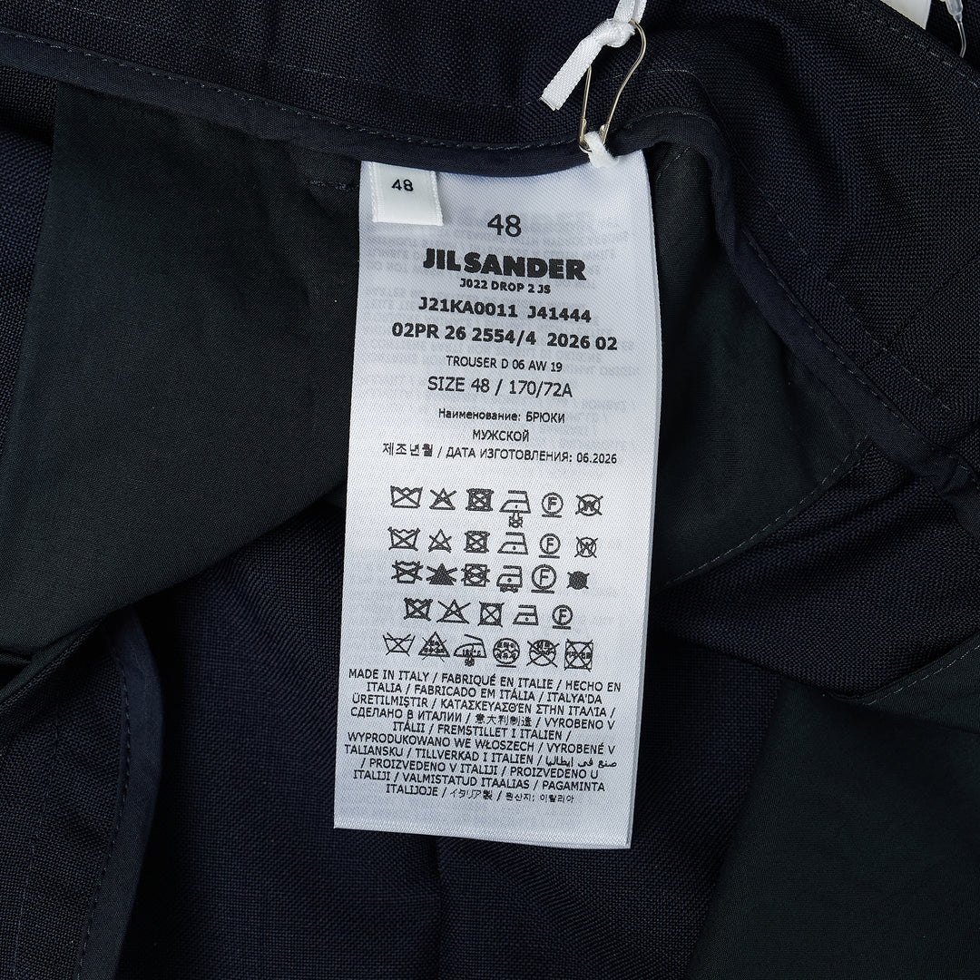 Jil Sander light brushed wool trousers in navy, featuring a high-rise waistband, pressed front creases, and a tapered straight-leg silhouette
