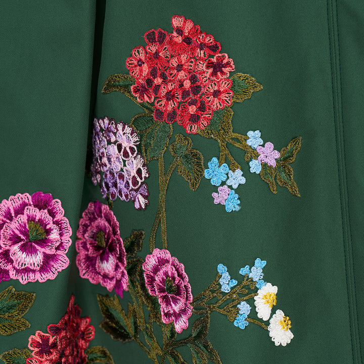 Carolina Herrera dark green A-line midi skirt with vibrant multicolour floral embroidery along the hem, featuring red, pink, and purple blooms with green leafy stems on both front panels