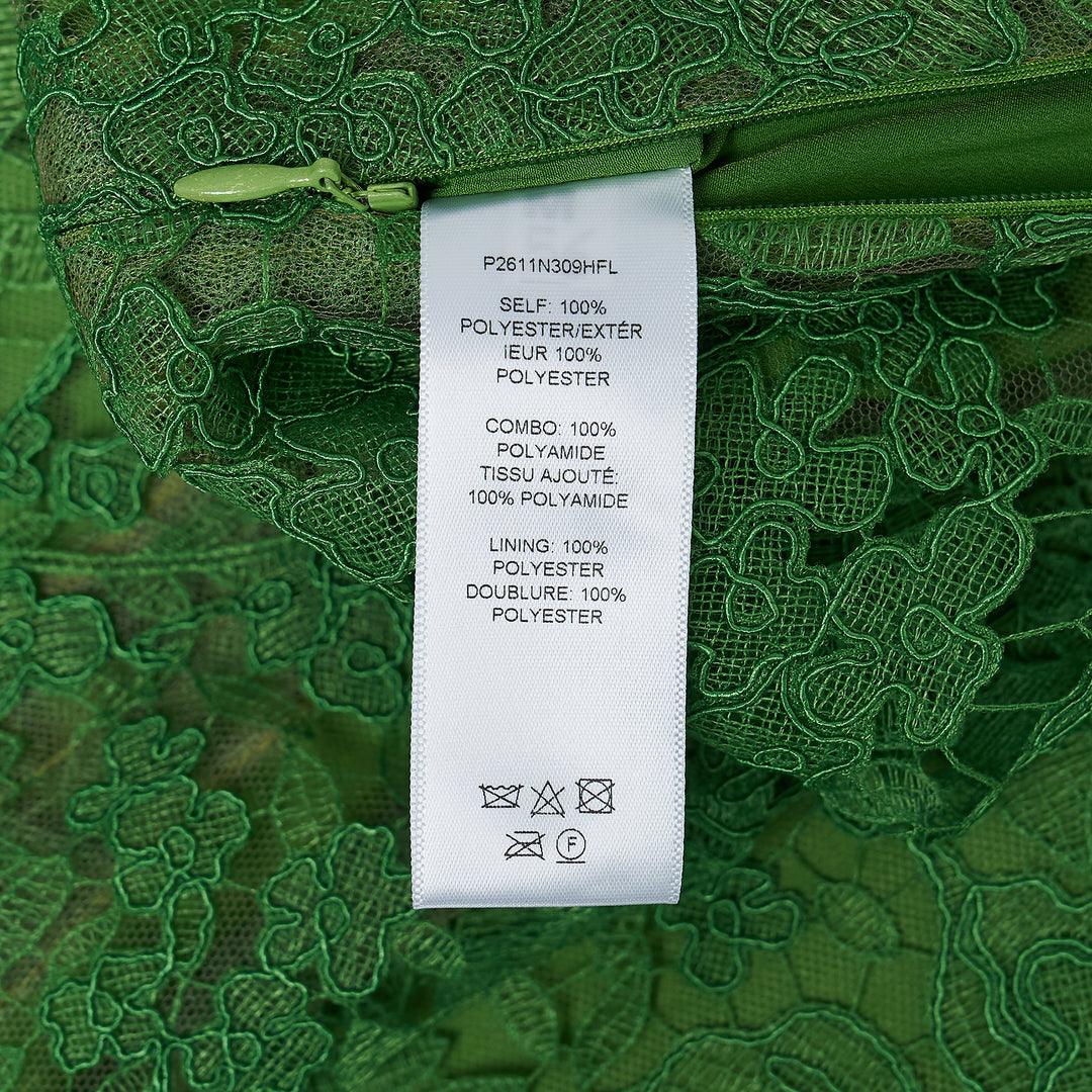 Carolina Herrera green floral guipure lace midi skirt with scalloped hem, pencil silhouette, and slip lining, shown flat against a white background