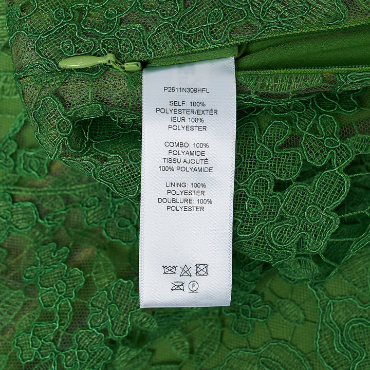 Carolina Herrera green floral guipure lace midi skirt with scalloped hem, pencil silhouette, and slip lining, shown flat against a white background