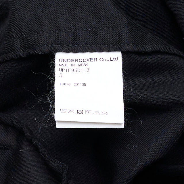 Undercover Elastic Waist Pants in black, featuring an elasticated waistband, front pleat, and tapered leg — front view on a flat lay