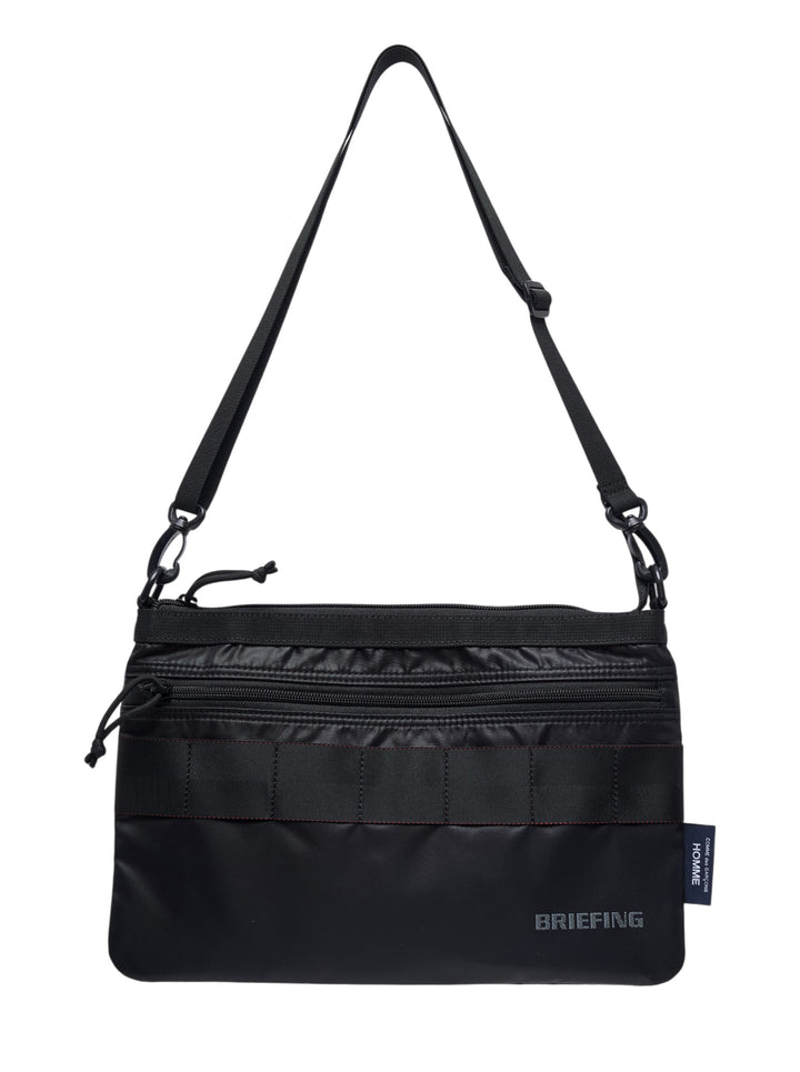 Black nylon duck sacoche crossbody bag with front zip pocket, webbing band, adjustable shoulder strap and Briefing branding