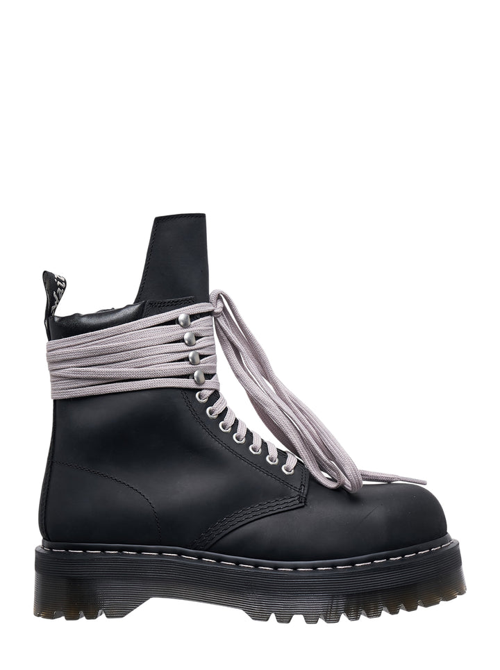 Rick Owens x Dr. Martens Quad Sole Steel Toe Boot in black leather with oversized pale lavender laces wrapped around the ankle and chunky ridged platform sole